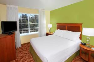 um quarto com uma cama, uma televisão e uma janela em TownePlace Suites San Jose Campbell em Campbell