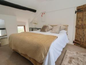 a bedroom with a large bed with white sheets at Nant Coed Annex in Abergele