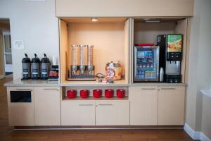 um café com copos vermelhos numa cozinha em TownePlace Suites San Jose Campbell em Campbell