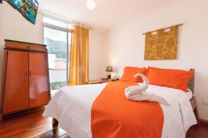 a bedroom with a bed with a swan on it at HOSTAL DEL RÍO in Ibarra