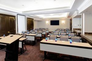 a conference room with tables and chairs and a screen at Courtyard by Marriott New York JFK Airport in Queens