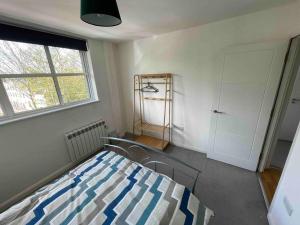 1 dormitorio con cama, ventana y puerta en 2 Bed city centre flat, en Bath