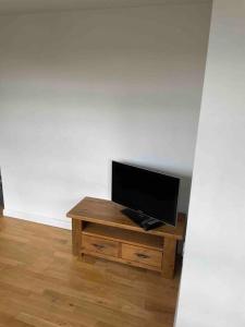 Une télévision à écran plat est installée au-dessus d'une table en bois. dans l'établissement 2 Bed city centre flat, à Bath