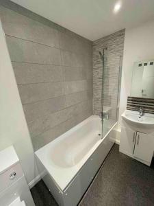 Baño blanco con bañera y lavamanos en 2 Bed city centre flat, en Bath