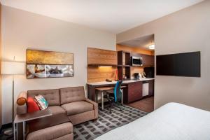 TownePlace Suites by Marriott Orlando Altamonte Springs/Maitland في أورلاندو: غرفة في الفندق مع أريكة ومكتب