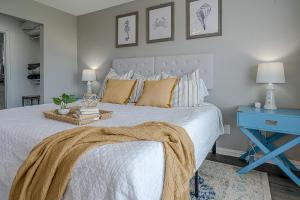 a bedroom with a white bed with a blue table at Hot Tub - Ocean Views - Steps to Private Beach - Quiet Location in Galveston +26 photos