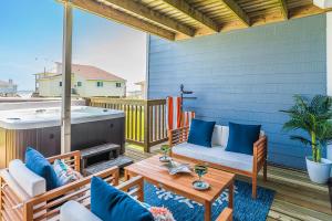 a patio with a table and chairs and a hot tub at Hot Tub - Ocean Views - Steps to Private Beach - Quiet Location in Galveston
