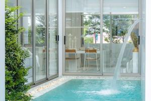 a swimming pool with a fountain in a house at The Residence by Andaman Phuket Free Airoport Pick up from 7 days in Ban Mut Dok Khao