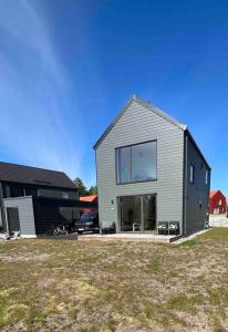 a gray house with a large window in a yard at Luxurious newly built villa with patio and private parking in Sigtuna
