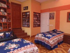 a bedroom with two beds and a book shelf at Casa Granada Jilotepec in Jilotepec