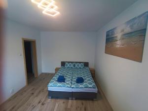 1 dormitorio con 1 cama y una pintura en la pared en Mewa86 en Gdynia