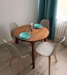 a wooden table with two chairs and a table with plates at Mewa86 in Gdynia