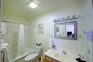 ein Badezimmer mit einem WC, einem Waschbecken und einem Spiegel in der Unterkunft Sitzmark Sports Lodge in Red River