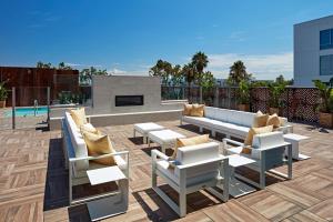 un patio con sofás y sillas y una chimenea en SpringHill Suites by Marriott Los Angeles Downey en Downey