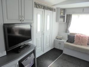 a living room with a flat screen tv and a couch at Highfields and Haven 8 Berth Tahiti in Lincolnshire