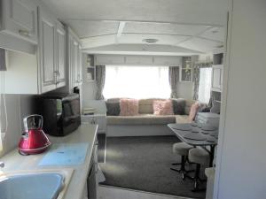 a kitchen and living room with a couch and a table at Highfields and Haven 8 Berth Tahiti in Lincolnshire