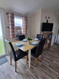 a dining room table and chairs in a living room at Holiday home in Dymchurch - New Beach Holiday Park in Dymchurch