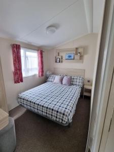 a bedroom with a bed with a checkered blanket at Holiday home in Dymchurch - New Beach Holiday Park in Dymchurch