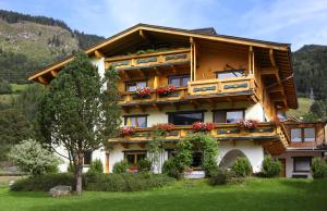 un grande edificio in legno con sopra dei fiori di Ferienwohnung Maxi a Maishofen