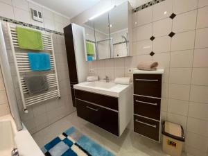 un bagno bianco con lavandino e specchio di Ferienwohnung Maxi a Maishofen