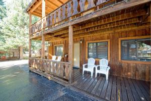 a porch of a wooden house with two chairs at Sitzmark Sports Lodge in Red River