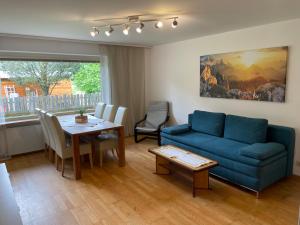 sala de estar con sofá azul y mesa en Ferienwohnung Maxi, en Maishofen