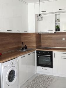 cocina con armarios blancos, lavadora y secadora en Zara Green Apartment 4 Guests Pet Friendly, en Stara Zagora