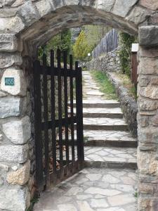 una entrada a una pared de piedra con puerta de hierro en Chalet Airaudi, en Saint-Martin-Vésubie