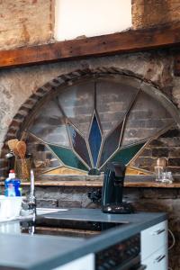 een keuken met een glas-in-loodraam boven een wastafel bij Ferienwohnungen Alte Destillerie in Neuwied