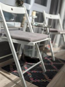 dos sillas blancas sentadas sobre una alfombra en Zara Green Apartment 4 Guests Pet Friendly, en Stara Zagora