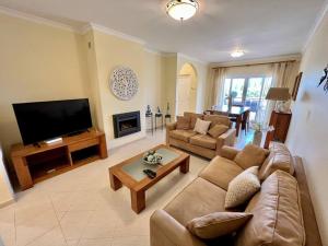 sala de estar con sofá y TV de pantalla plana en Quinta da Boa Nova - Cheerful and spacious 2-bedroom duplex, en Estômbar