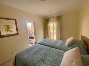 1 dormitorio con 2 camas individuales y ventana en Quinta da Boa Nova - Cheerful and spacious 2-bedroom duplex, en Estômbar