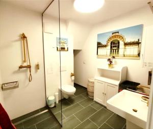uma casa de banho com um chuveiro, um WC e um lavatório. em Imperial Sisi Residence-Concept Style Apartment em Viena
