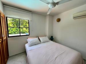 1 dormitorio con cama blanca y ventana en A pasos de la playa! Acogedor apartamento en Bello Horizonte con Balcón I WiFi, en Playa Dormida