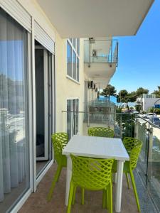 a patio with a white table and chairs on a balcony at Marjana's Sea View Apartment 1 in Lezhë