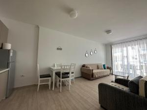 a living room with a table and a couch and a table and chairs at Marjana's Sea View Apartment 1 in Lezhë