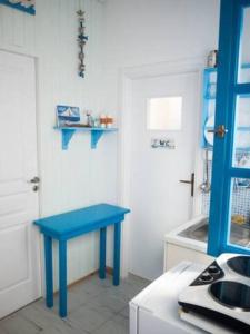 a blue table in a kitchen next to a door at Amorgos Azur apartment in Tholária
