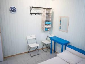 a room with a blue table and two chairs and a clock at Amorgos Azur apartment in Tholária
