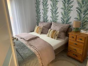 a bedroom with a bed with pillows and a window at Przy Złotych Piaskach in Sława