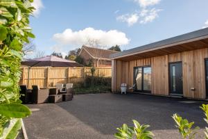 a patio with chairs and a house at The Gatehouse Axminster in Axminster