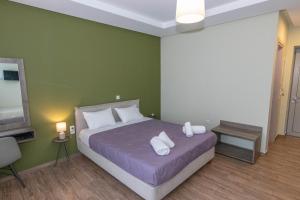 a bedroom with a bed with two pillows and a tv at Verga's Apartments in Kalamata