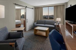 a hotel room with a couch and a tv and a bed at Delta Hotels by Marriott Santa Clara Silicon Valley in Santa Clara