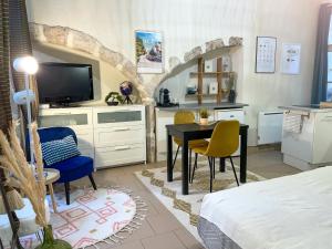 een slaapkamer met een tafel en stoelen en een televisie bij Charme & calme à 200m du Château in Blois