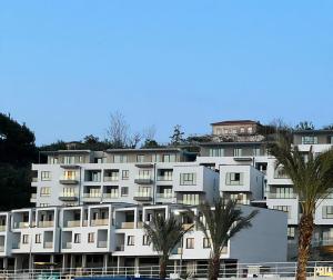 um grande edifício branco com palmeiras em frente em Sunset Resort em Vlorë