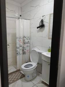Baño blanco con aseo y lavamanos en Tres Fronteras Apart 1 en Puerto Iguazú
