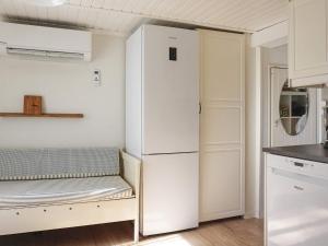 a white refrigerator in a kitchen with a bench at 4 person holiday home in Fjällbacka-By Traum in Fjällbacka