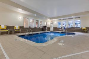 a pool in a hotel with chairs and a table at Fairfield Inn & Suites by Marriott Rogers in Rogers