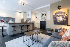 a living room with a couch and a kitchen at HIGHLAND Annecy Rent Lodge in Annecy