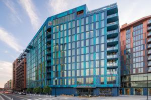 un edificio azul con ventanas de cristal en una calle en AC Hotel by Marriott Washington DC Capitol Hill Navy Yard en Washington