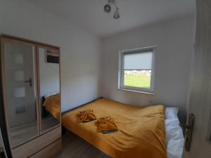 niewielka sypialnia z łóżkiem i oknem w obiekcie Pod Górką w mieście Lądek-Zdrój